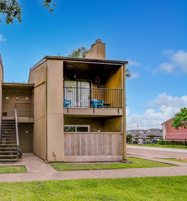 3300 Pebblebrook Dr Unit 15, Seabrook, TX 77586 - rear view of house featuring a chimney, stairs, and a balcony