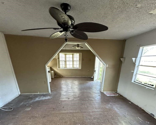 bonus room with ceiling fan and a textured ceiling
