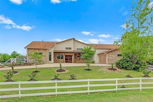 view of front of house with stucco siding, fence private yard, a front lawn, and stone siding