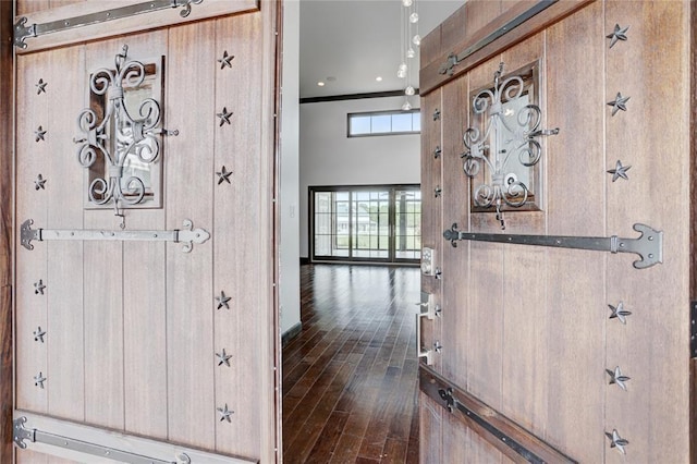 entrance foyer with wooden walls and dark wood finished floors