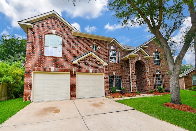 traditional-style home with concrete driveway, brick siding, an attached garage, and a front yard