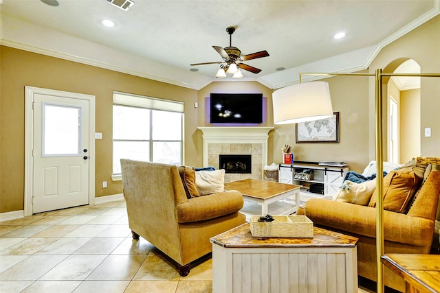 living area featuring a fireplace, a ceiling fan, light tile patterned floors, lofted ceiling, and ornamental molding
