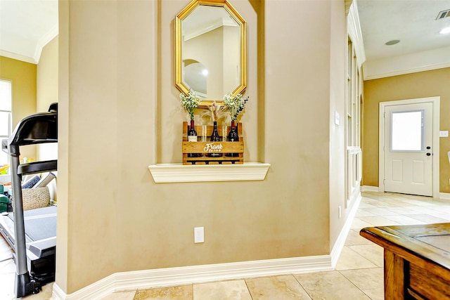 hallway featuring tile patterned flooring, ornamental molding, baseboards, and visible vents