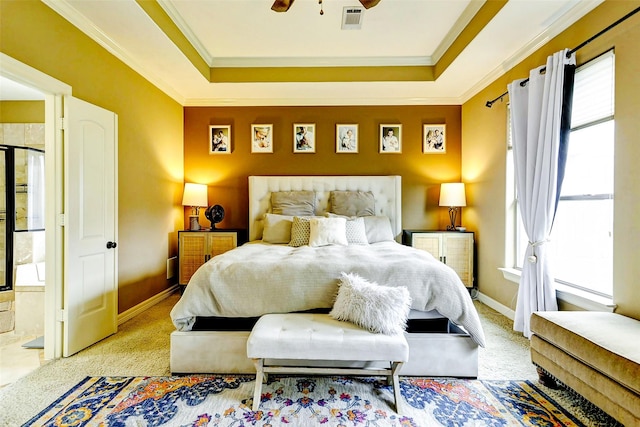 bedroom featuring light carpet, baseboards, a tray ceiling, visible vents, and ornamental molding