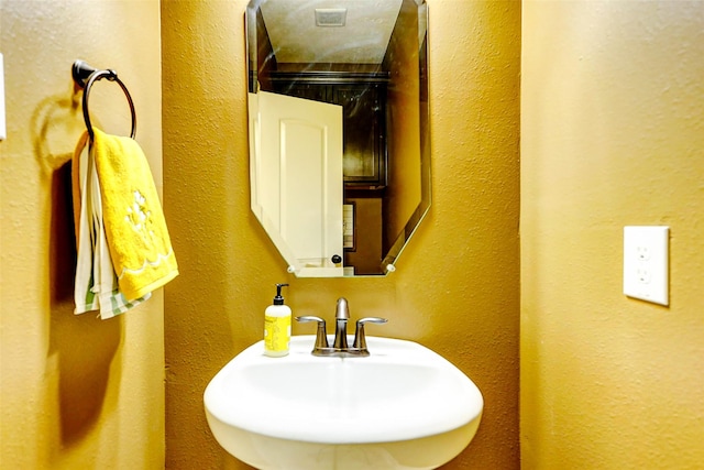 bathroom with a textured wall and a sink