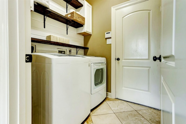 laundry room with light tile patterned floors, separate washer and dryer, and cabinet space