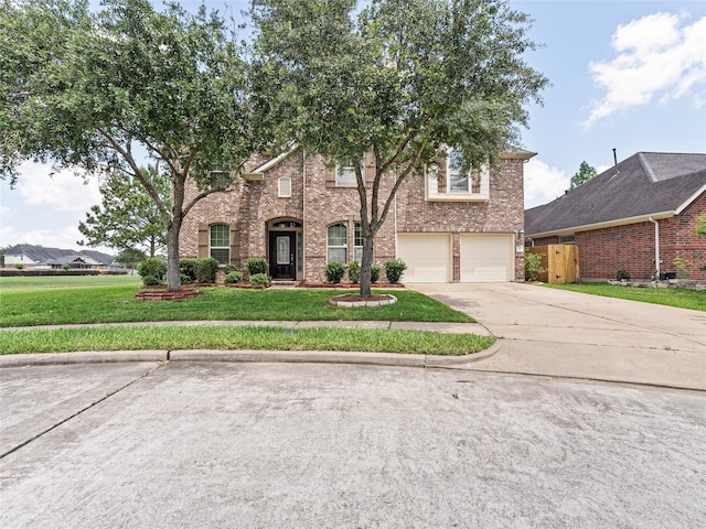 traditional-style house featuring driveway, a front yard, brick siding, fence, and an attached garage