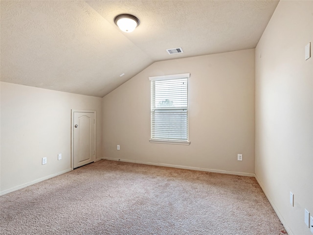 bonus room featuring visible vents, a textured ceiling, vaulted ceiling, and light carpet
