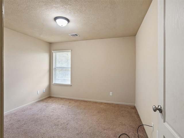 unfurnished room with baseboards, carpet flooring, a textured ceiling, and visible vents