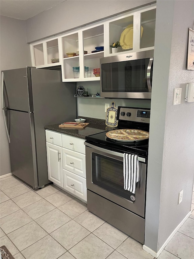 kitchen with appliances with stainless steel finishes, open shelves, baseboards, white cabinets, and light tile patterned flooring