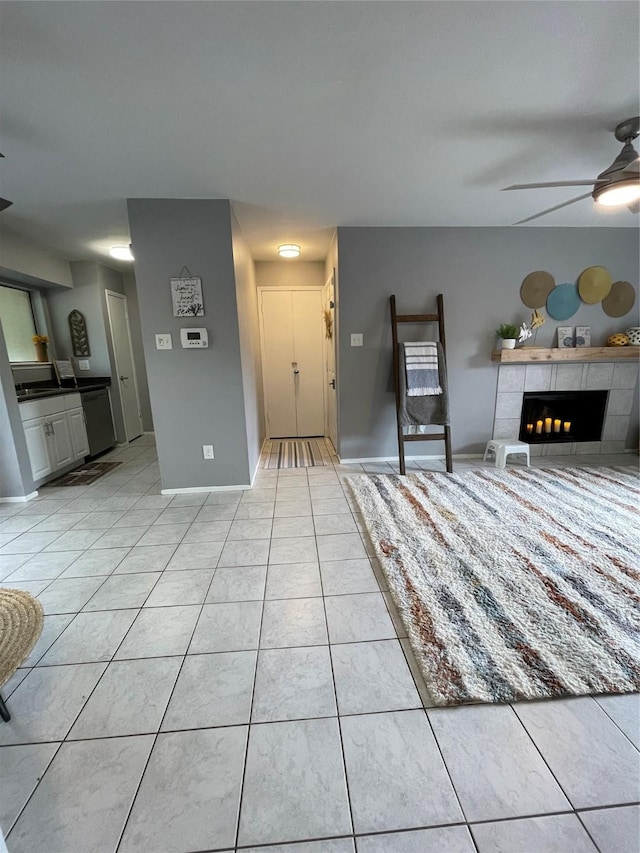 interior space featuring ceiling fan, light tile patterned floors, and a tile fireplace