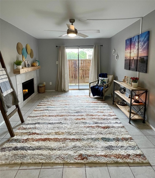 sitting room featuring tile patterned flooring, baseboards, ceiling fan, and a tile fireplace