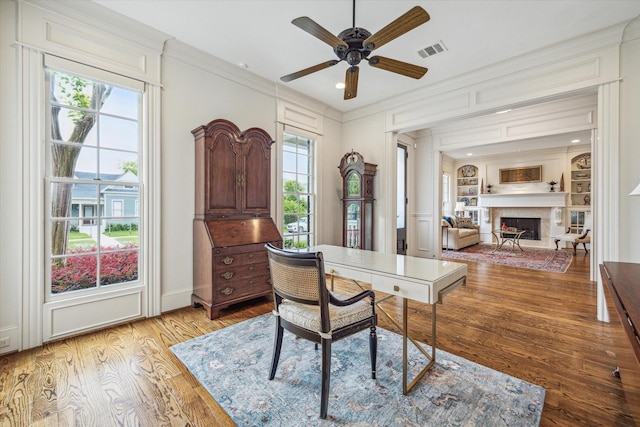 office featuring visible vents, crown molding, ceiling fan, and wood finished floors