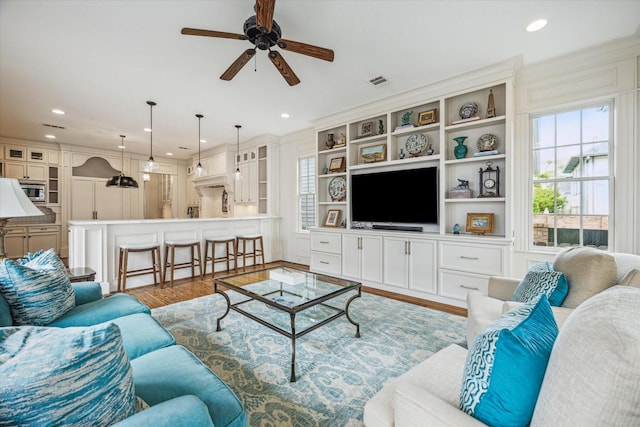 living area with recessed lighting, ceiling fan, visible vents, and wood finished floors