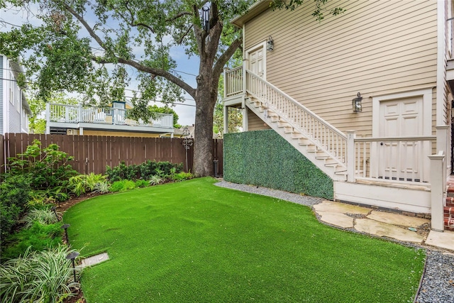 view of yard with a fenced backyard and stairs
