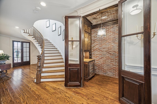 interior space featuring french doors, recessed lighting, brick wall, and wood finished floors
