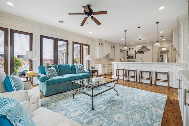 living area featuring a ceiling fan, recessed lighting, wood finished floors, and visible vents
