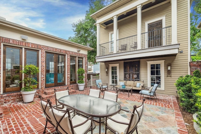 view of patio featuring french doors, outdoor dining space, outdoor lounge area, and a balcony
