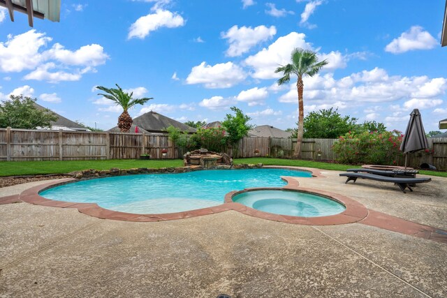view of swimming pool with a pool with connected hot tub, a fenced backyard, and a patio area