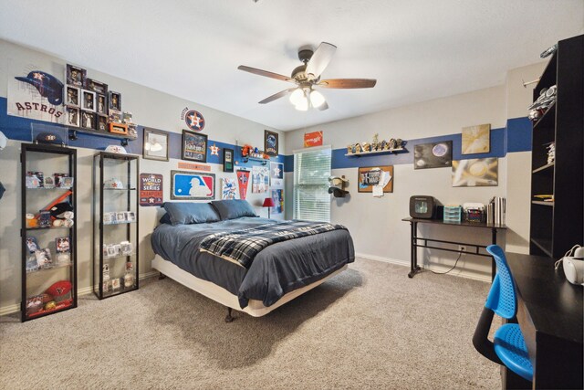 carpeted bedroom featuring baseboards and ceiling fan
