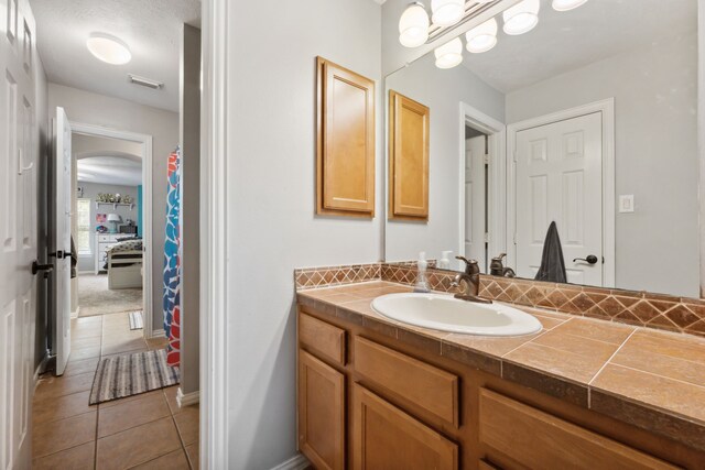 bathroom with vanity, baseboards, tile patterned floors, and visible vents