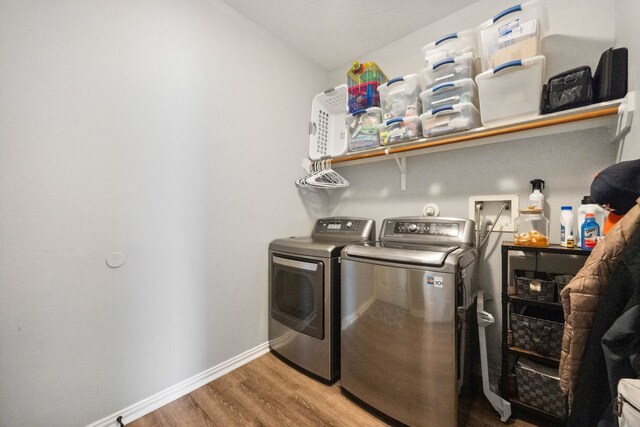 laundry room with baseboards, laundry area, independent washer and dryer, and wood finished floors