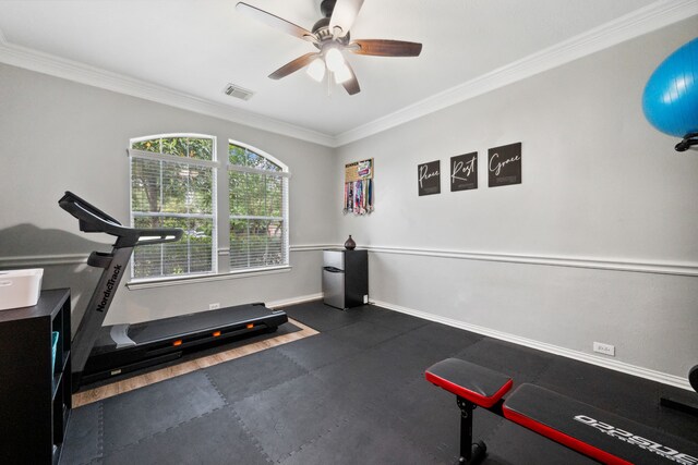 exercise room featuring crown molding, baseboards, a ceiling fan, and visible vents