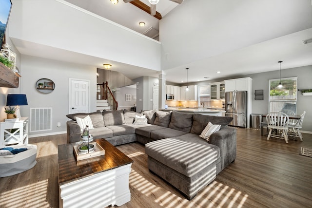 living room with baseboards, dark wood-style flooring, stairs, and visible vents