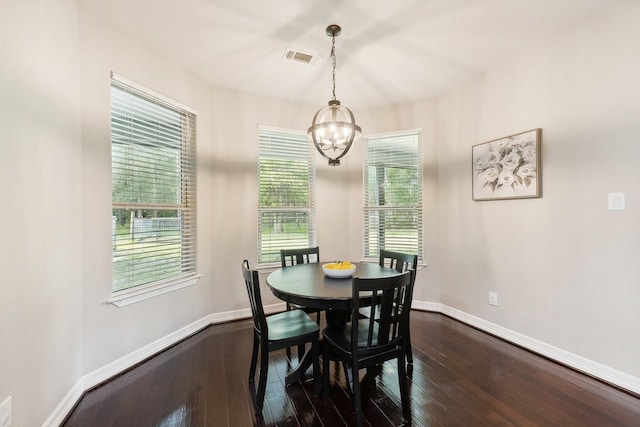 dining space with baseboards, dark wood finished floors, a chandelier, and visible vents