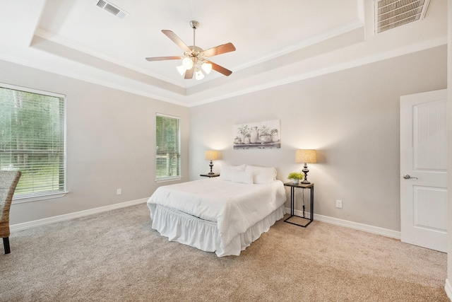 bedroom featuring visible vents, multiple windows, and a raised ceiling