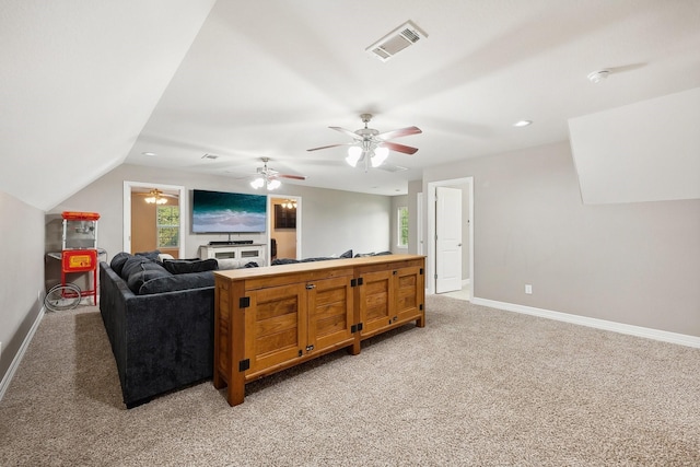 living room featuring visible vents, lofted ceiling, light carpet, baseboards, and ceiling fan