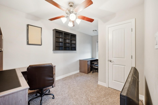 office featuring baseboards, ceiling fan, and light carpet