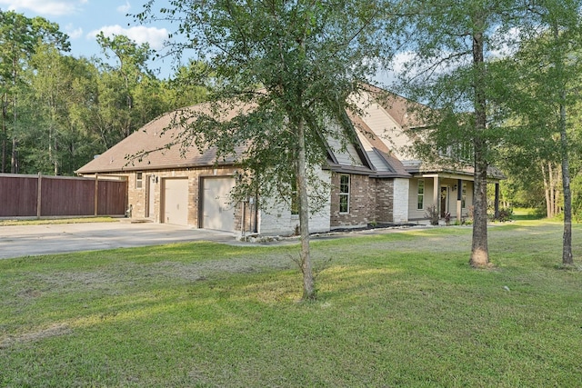 view of front of home with brick siding, a front lawn, fence, and concrete driveway