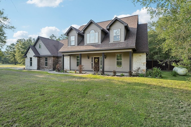 view of front of property with a porch, a shingled roof, a front lawn, and stone siding