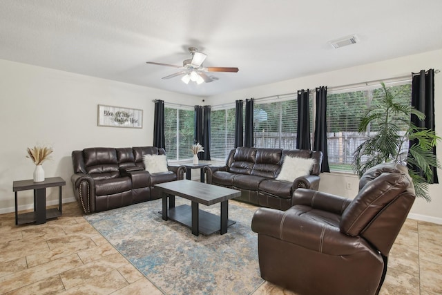 21894 Pinewilde Ct, Porter, TX 77365 - living area with visible vents, a ceiling fan, baseboards, and stone finish flooring