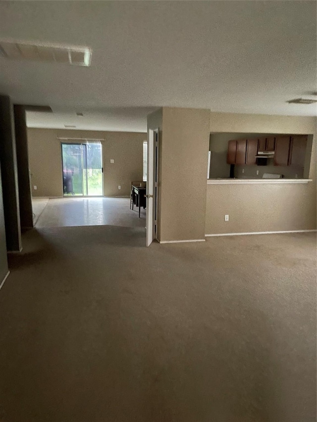 unfurnished living room featuring carpet floors and baseboards