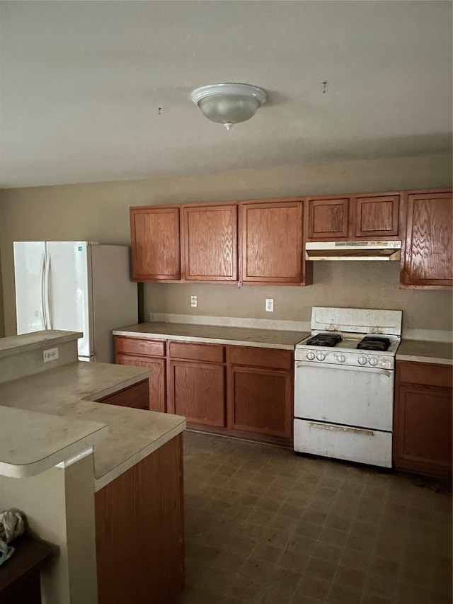 kitchen with light countertops, brown cabinets, under cabinet range hood, and white appliances