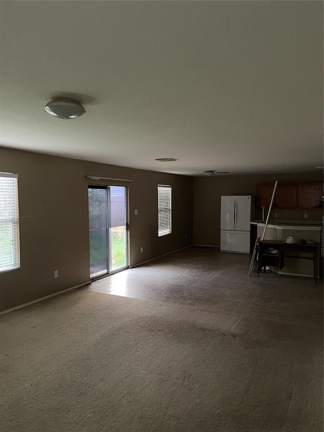 carpeted empty room featuring baseboards