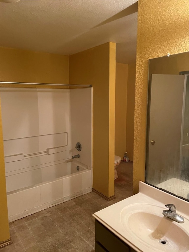 bathroom with a textured wall, vanity, toilet, a textured ceiling, and tile patterned floors