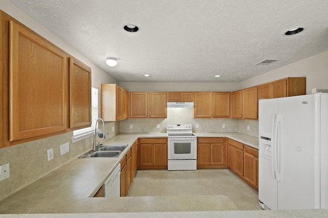 kitchen with white appliances, light countertops, under cabinet range hood, a sink, and backsplash