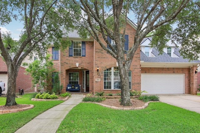 traditional-style house with concrete driveway, brick siding, a shingled roof, and a front yard