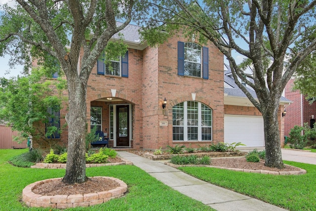 traditional home with driveway, a front lawn, and brick siding