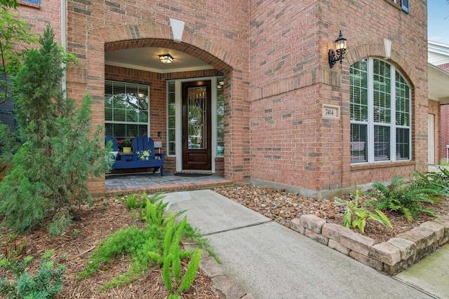 view of exterior entry featuring brick siding