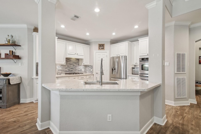 kitchen with visible vents, tasteful backsplash, light stone counters, a sink, and stainless steel appliances