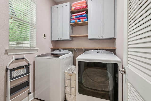 clothes washing area featuring cabinet space and separate washer and dryer