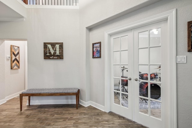 doorway featuring french doors, baseboards, and wood finished floors