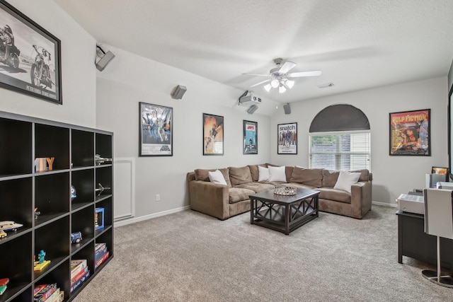 living room with carpet floors, a ceiling fan, baseboards, and vaulted ceiling
