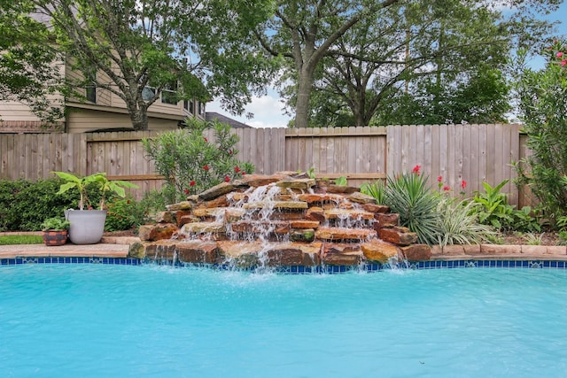 view of swimming pool featuring fence