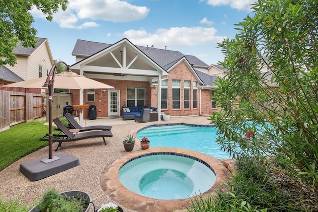 rear view of property with outdoor lounge area, a patio, brick siding, a fenced in pool, and an in ground hot tub