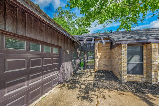 view of property exterior with brick siding, an attached garage, driveway, and roof with shingles